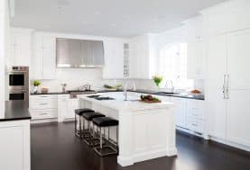 An all-white kitchen with silver appliances and dark wood floor