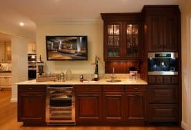 A bar area with white countertops and dark wood cabinetry