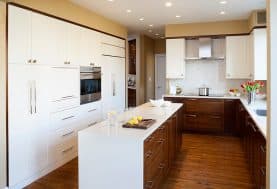An all white kitchen with wooden drawers