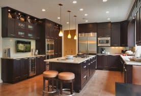 A dark brown kitchen with floor to ceiling cabinetry and a large center island