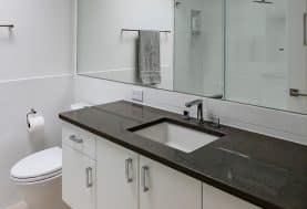 A modern black and white bathroom with a large mirror