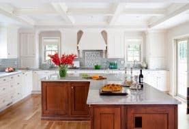 A white kitchen with a dark wood island and floors.