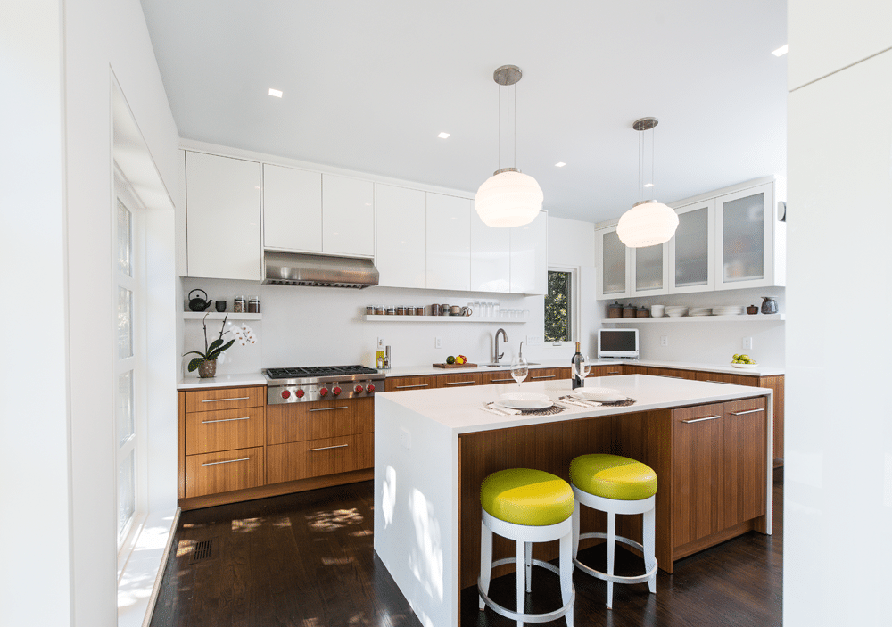 White and wood-toned kitchen with yellow and white stools beneath the island.