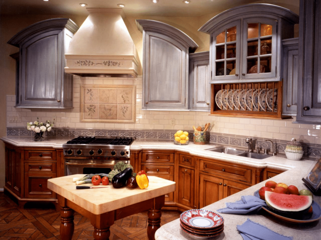 Custom kitchen cabinets, with gray cabinets above counter and wood-grain below.